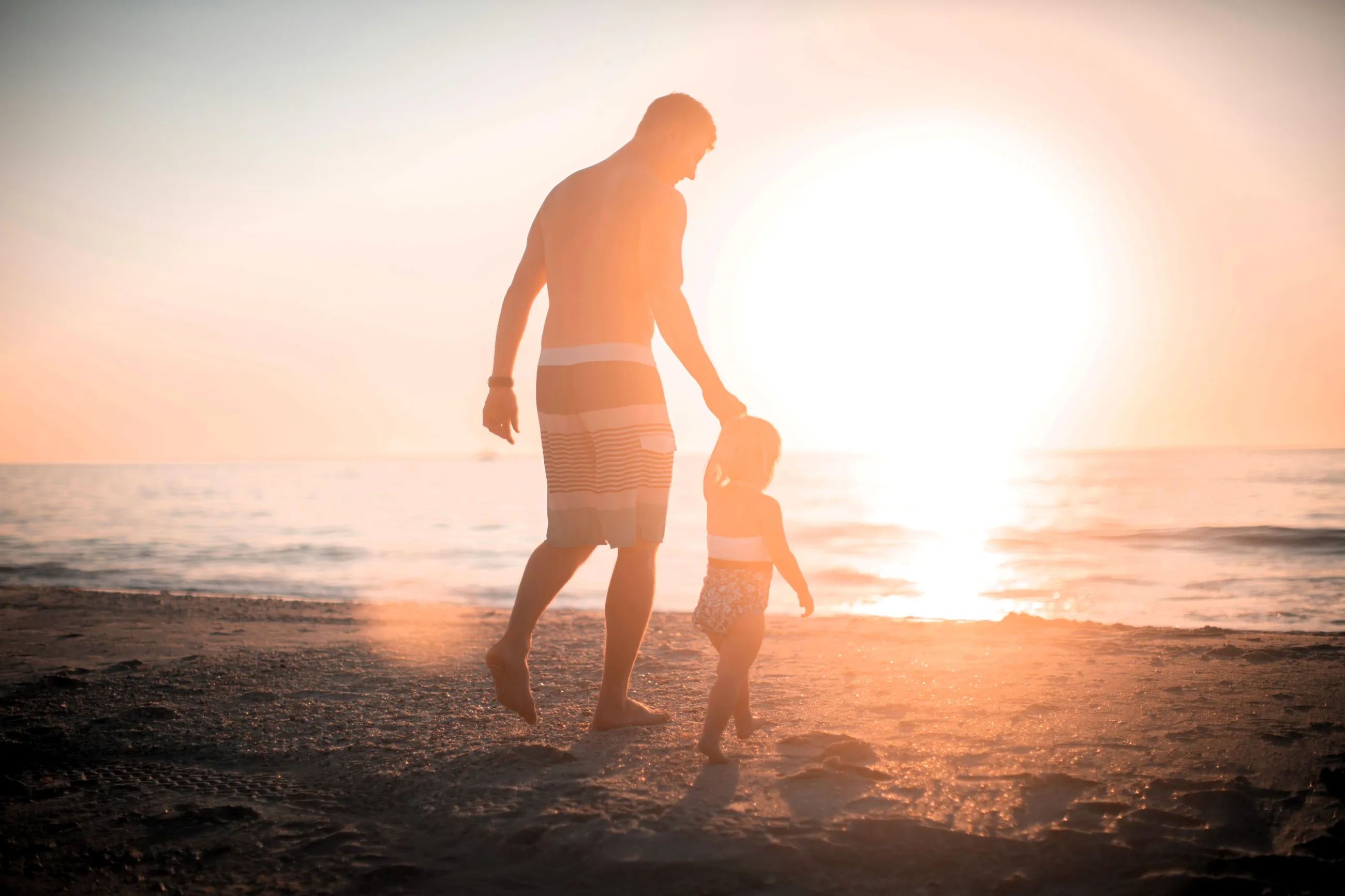 Man and child walking on the beach